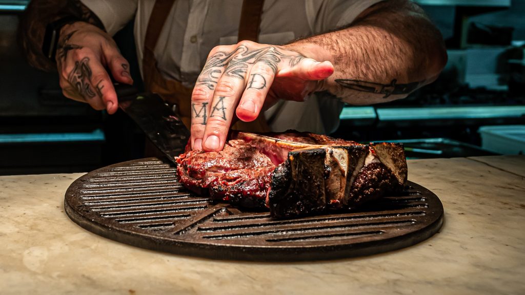 A chef carving a steak at Chop House, Edinburgh